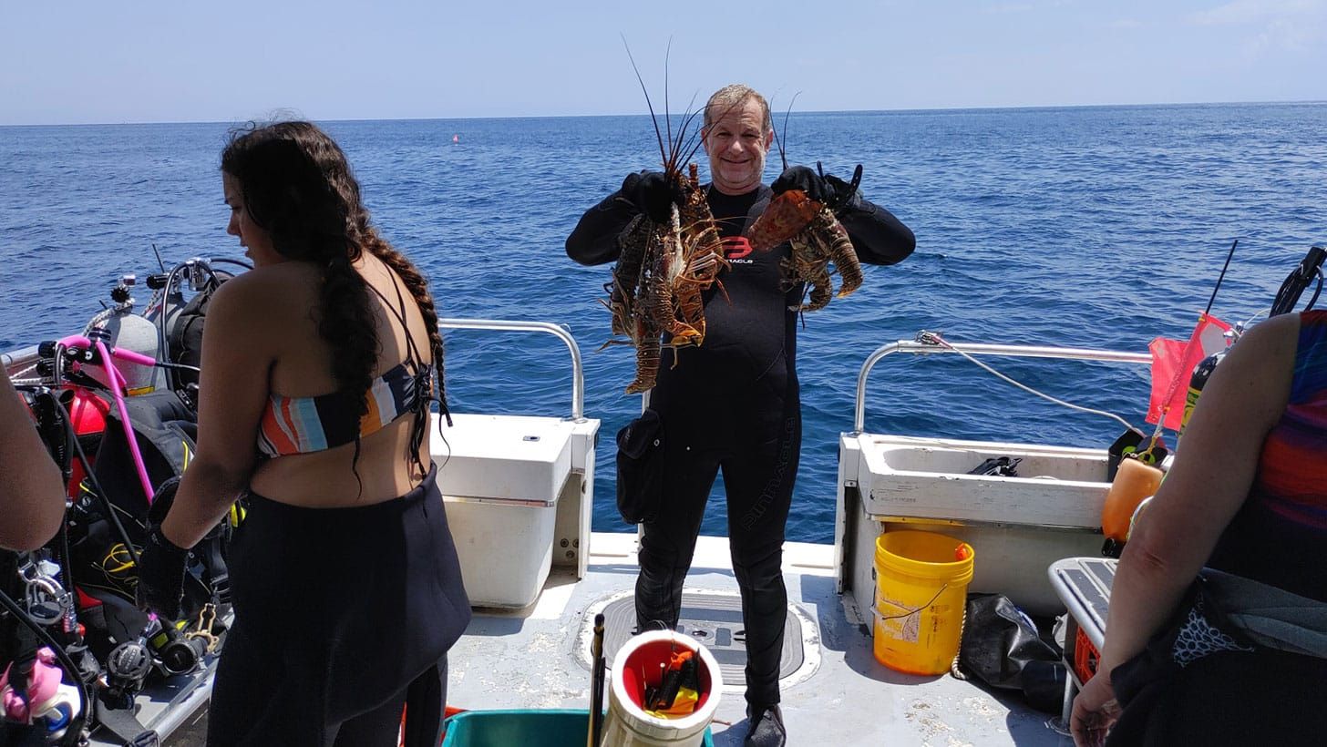 diversity diveboat guest with a lot of lobster